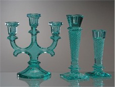 Green candlesticks made of glass colored by iron